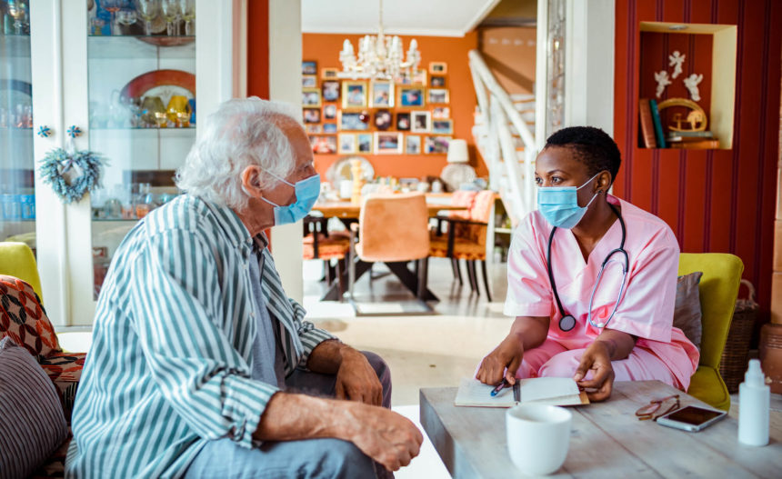 Healthcare worker at home with older man