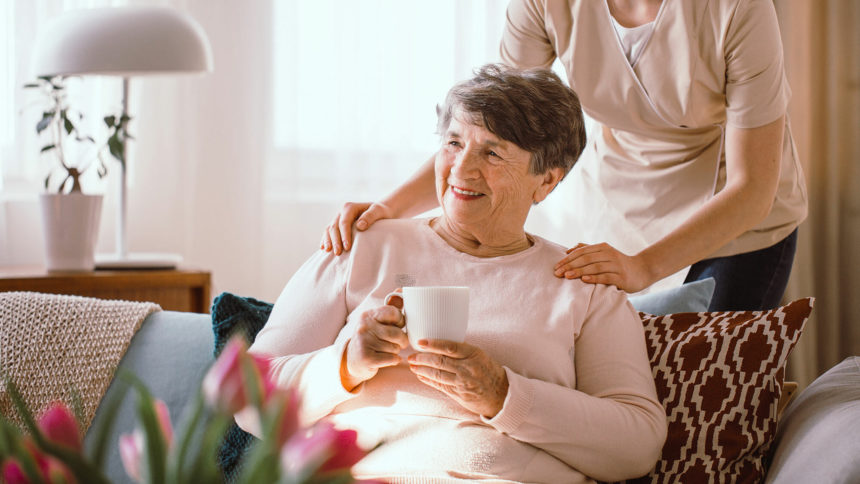 caregiver with hands on older adults' shoulders