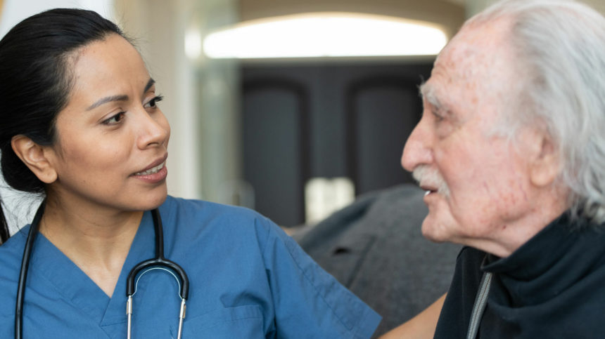 healthcare worker talking with older man