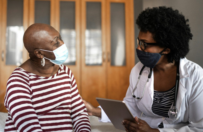 Black healthcare worker talking with Black woman