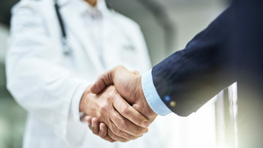 Doctor shakes hand with business person