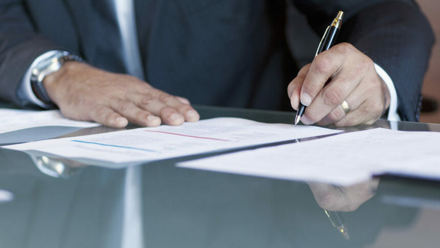 Businessman signing contract at table