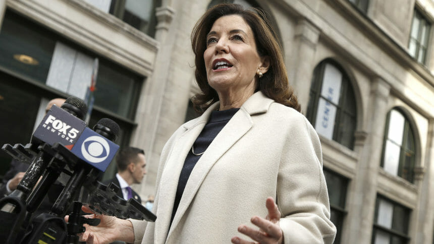 NY Gov. Kathy Hochul stands before microphones