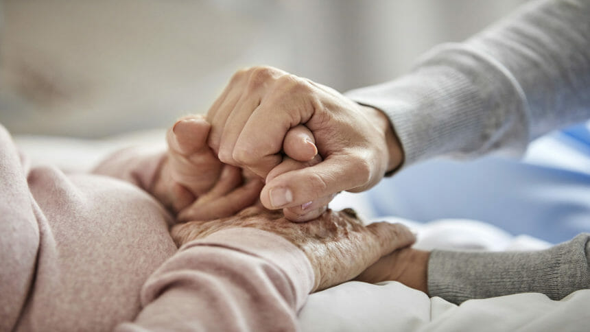 elderly woman's hands with caregiver's