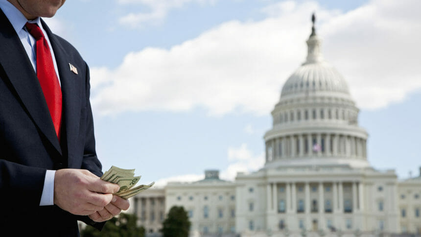 man counting money before U.S. Capitol