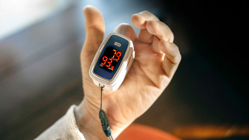 of oximeter for checking oxygen saturation in blood on male hand.
