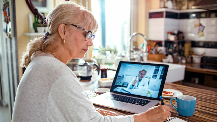 Close up of a senior woman consulting with her doctor online on her laptop