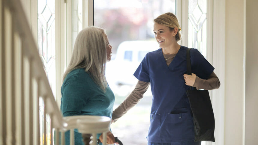 Nurse talking to patient in front door