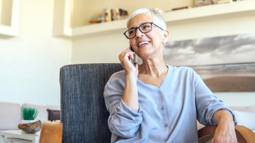 Senior woman having a mobile phone conversation while resting at home