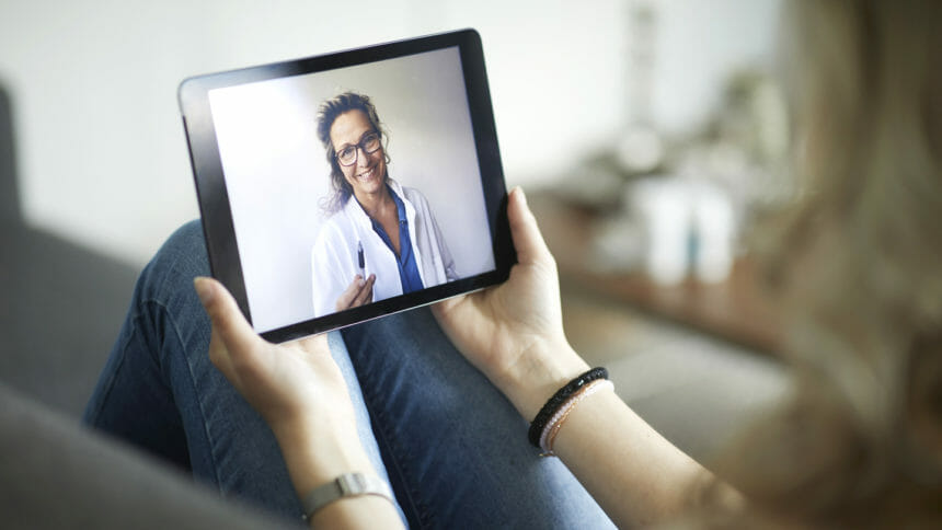 Young woman having online meeting with female telehealth person