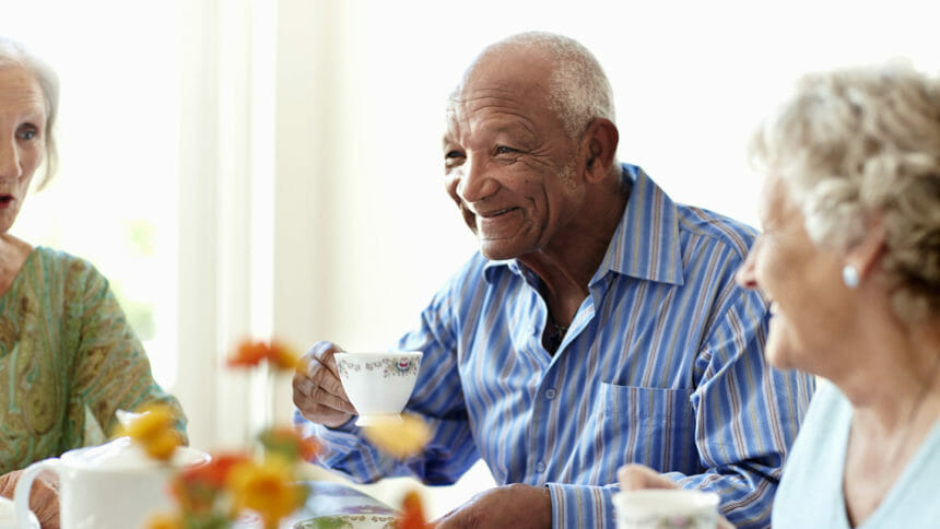 Smiling senior man having coffee with friends