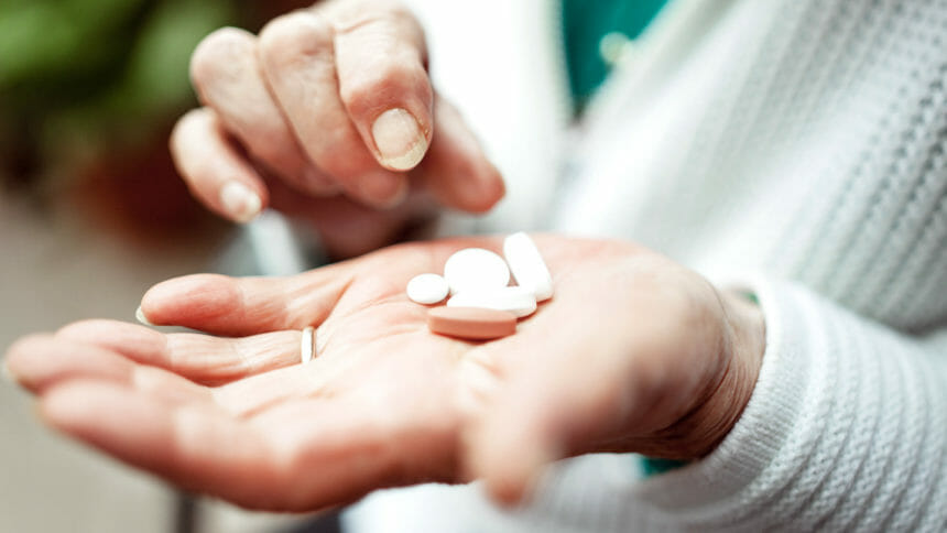 Senior woman holding pills selection in her hands, close-up.