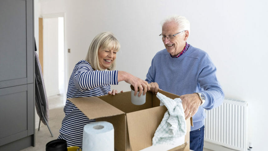 two seniors unpacking a box