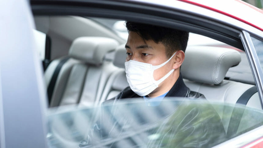 young Asian man with face mask to protect and prevent from the spread of viruses in car