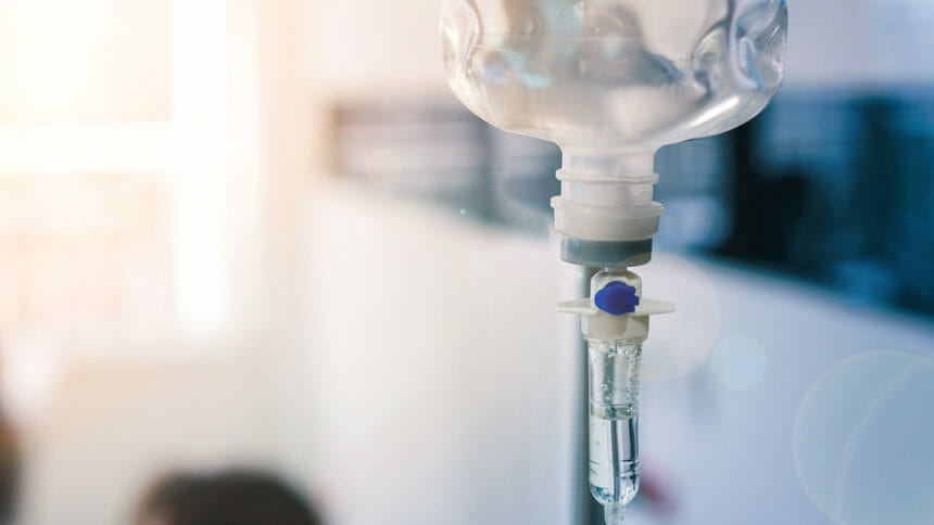 Close up of medical drip or IV drip chamber in patient room, Selective focus