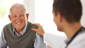 A doctor and elderly man share a friendly