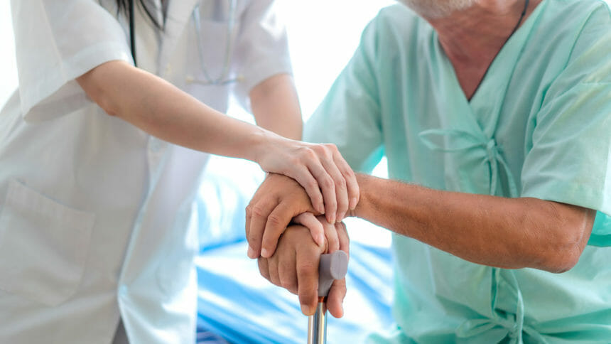 physician hands over elderly patient's hands