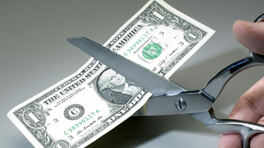 Dollar being cut with scissors