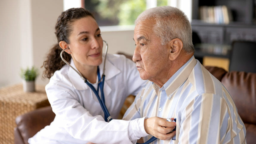 Clinician checking heart of older man
