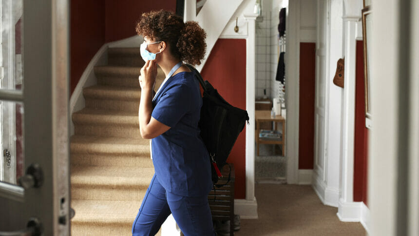 Side view of female caregiver going for work during COVID-19