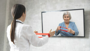 Therapist uses armband with senior who is on-screen.