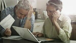 Stressed Hispanic couple paying bills on laptop