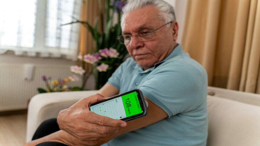 Senior man checking blood glucose level on an app