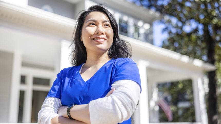 Portrait of nurse in front of suburban home