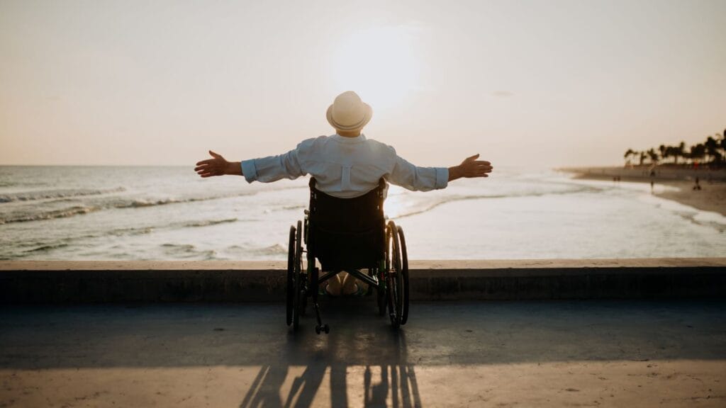 A senior in a wheelchair gazes at the sunrise.
