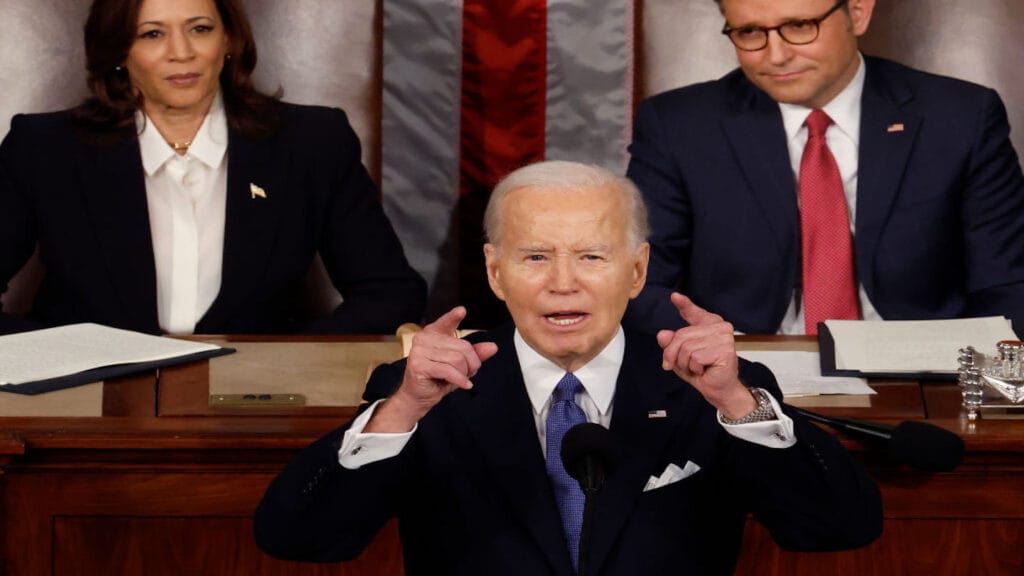 President Biden speaks at State of the Union wile Vice President Kamala Harris and Speaker of the House Mike Johnson look on.