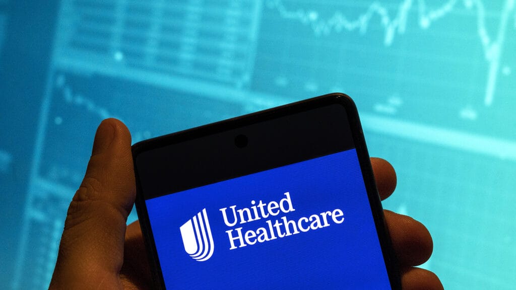 CHINA - 2023/02/19: In this photo illustration, the American multinational managed healthcare and insurance company UnitedHealth logo is seen displayed on a smartphone with an economic stock exchange index graph in the background. (Photo Illustration by Budrul Chukrut/SOPA Images/LightRocket via Getty Images)