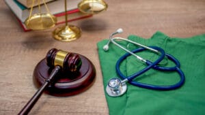A gavel and a stethoscope on a wooden table